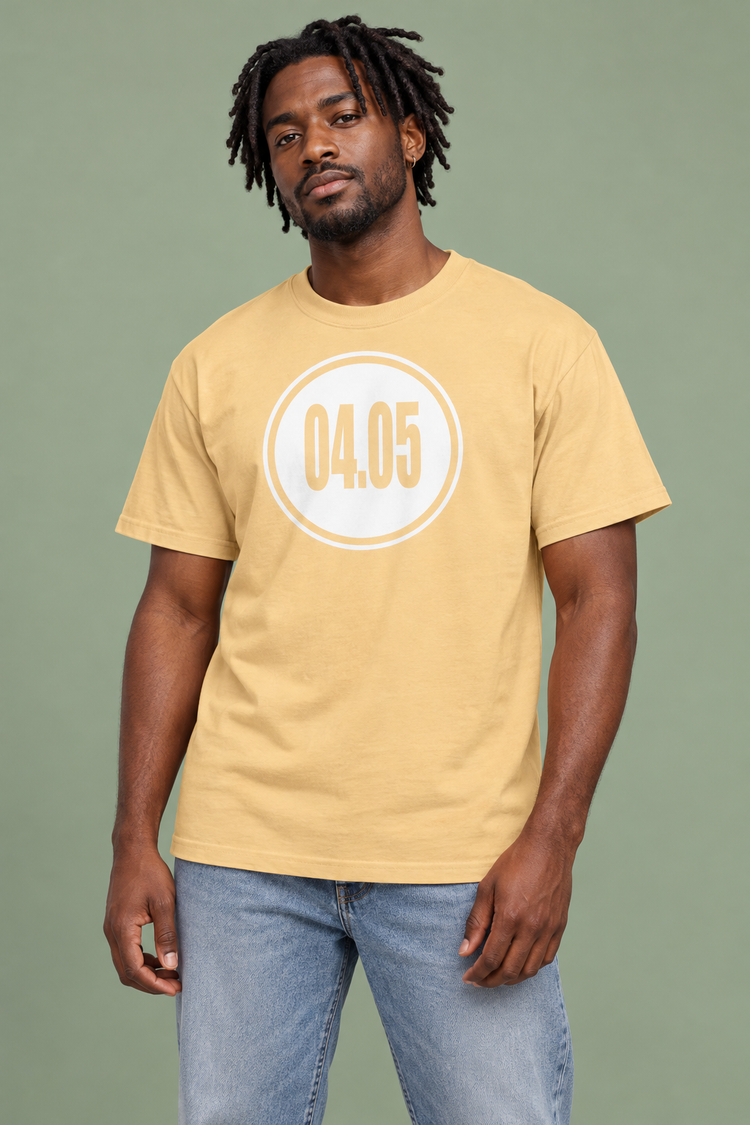 AI-generated Black man age 30, dark brown skin, medium build, short locs wearing Men’s 04.05 Bordered Circle Classic Tee — Yellow Haze; clean muted sage studio