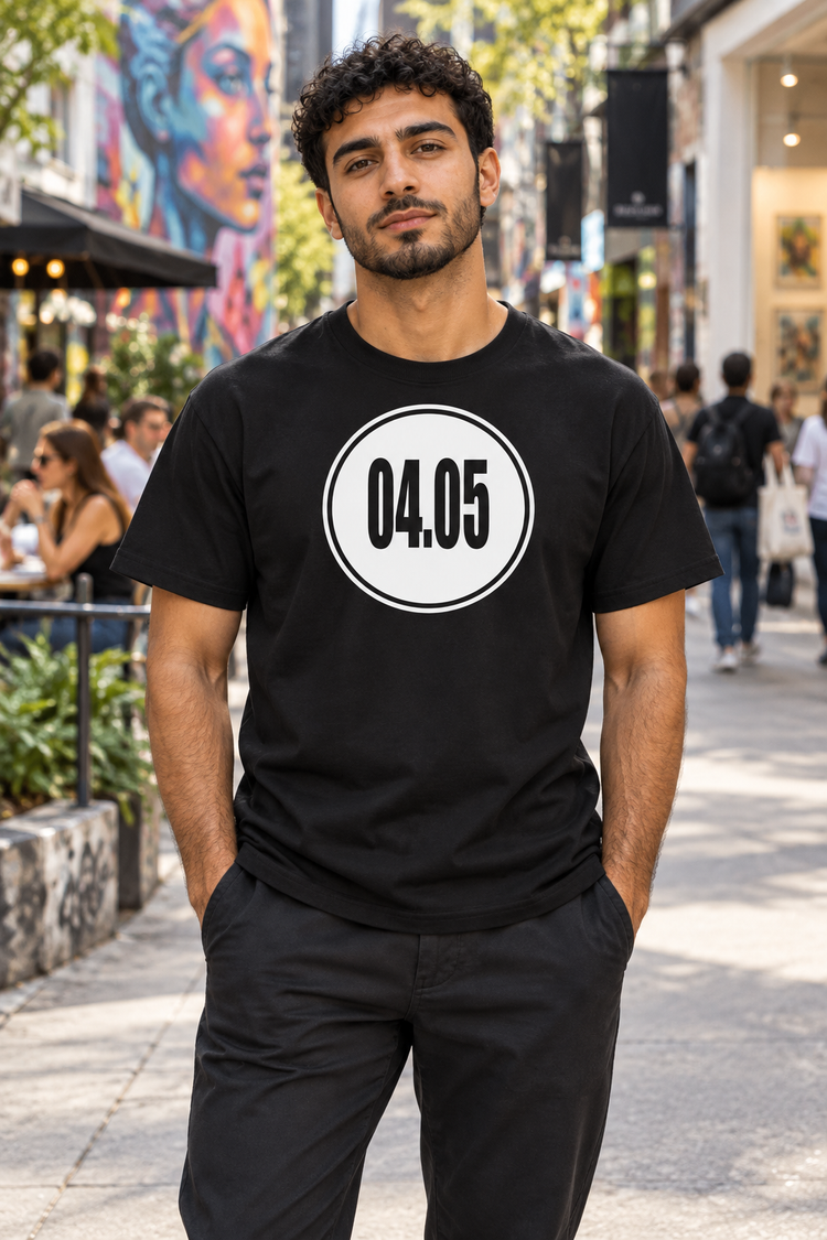 AI-generated Middle Eastern man age 25, olive skin, medium build, short curly hair wearing Men’s 04.05 Bordered Circle Classic Tee — Black; busy downtown gallery district with murals, shoppers and cafes