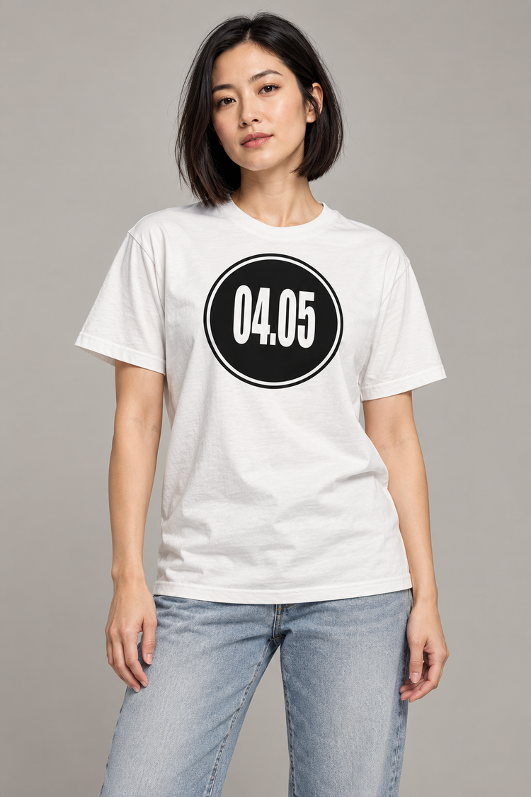AI-generated East Asian woman age 29, light skin, athletic build, straight dark bob wearing Women’s 04.05 Bordered Circle Classic Tee — White; clean warm gray studio